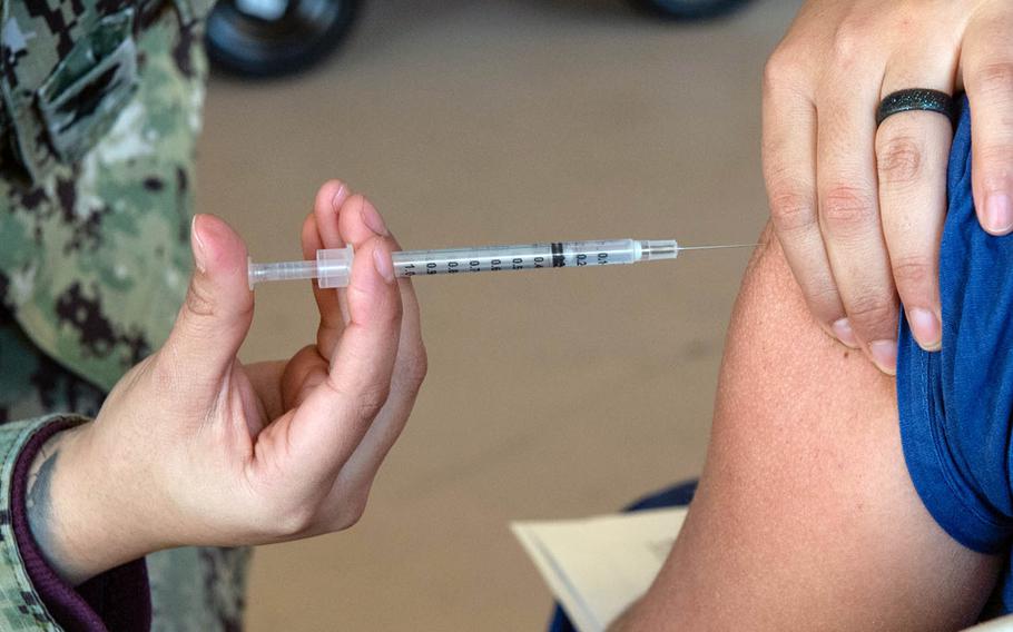 One of the first doses of Pfizer's COVID-19 vaccine is given at Naval Medical Center San Diego, Tuesday, Dec. 15, 2020. 