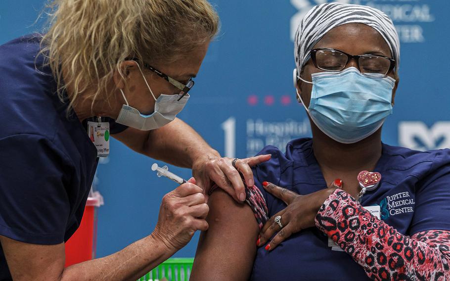 Jupiter Medical Center Chief Nursing Officer Pam Canter, Jupiter, injects nurse Ann Marie Cole with the COVID-19 vaccine at the campus in Jupiter, Fla., on Wednesday, December 23, 2020.