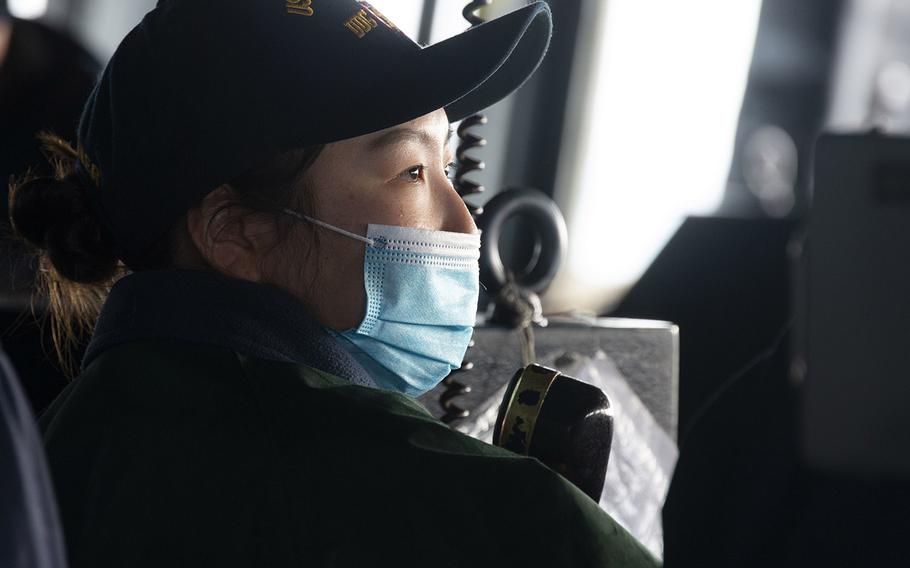 Ensign Vanessa Echols from Toumon, Guam, talks into a telephone aboard the Arleigh Burke-class guided-missile destroyer USS Curtis Wilbur on Dec. 26, 2020. 