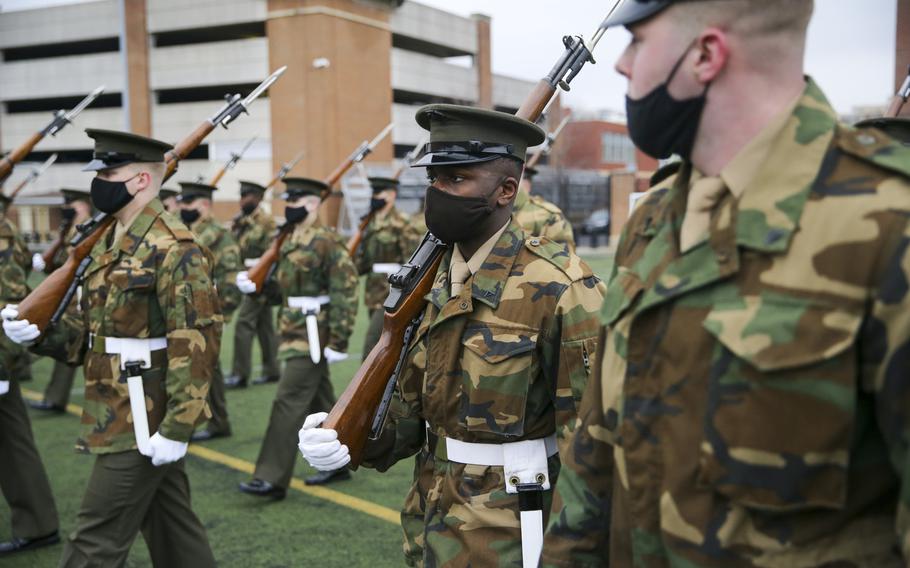 Marines with Marine Barracks Washington prepare on Jan. 5, 2021, in Washington, D.C., for the presidential inauguration. The Marines are wearing an unusual combination of a Vietnam-era field jacket in woodland camouflage with their khaki-and-olive green service dress uniforms.

