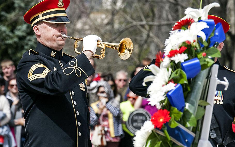 A service member plays taps during a wreath-laying ceremony at the Tomb of the Unknown Soldier in Arlington National Cemetery during Medal of Honor Day, March 25, 2016.