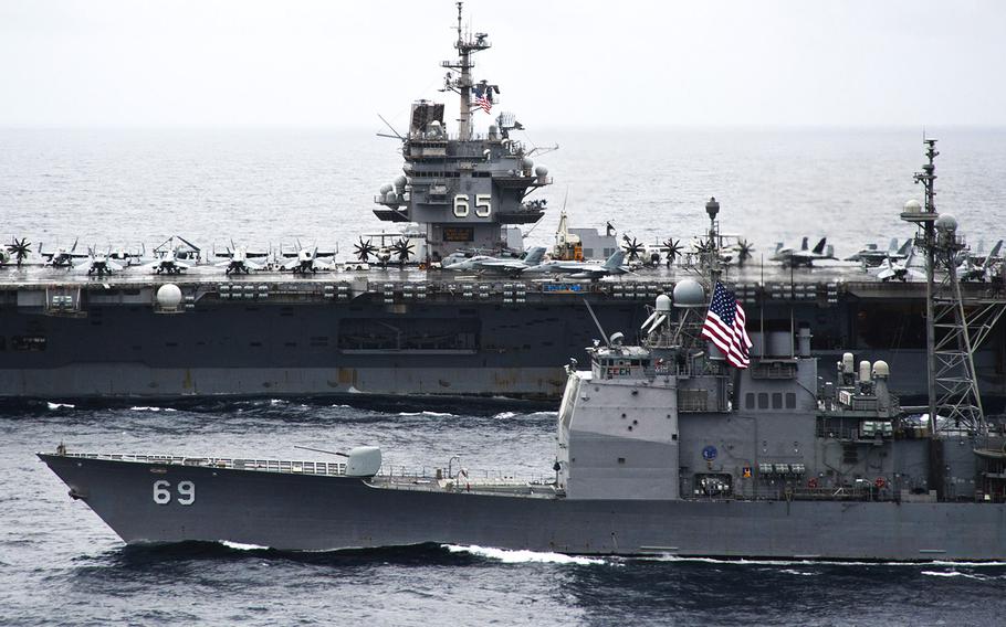 The guided-missile cruiser USS Vicksburg maneuvers alongside the aircraft carrier USS Enterprise while underway in the Atlantic Ocean.