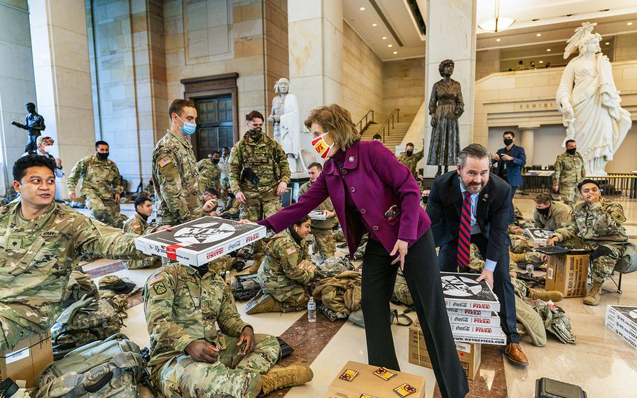 Rep. Vicky Hartzler, R-Mo., and Rep. Michael Waltz, R-Fla., hand pizzas to members of the National Guard gathered at the Capitol Visitor Center, Wednesday, Jan. 13, 2021, in Washington.