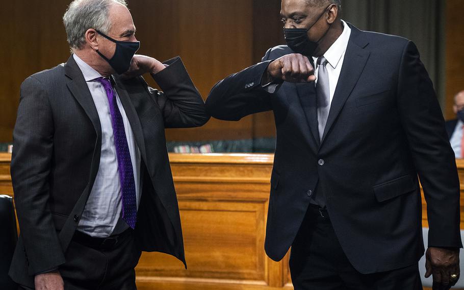 Secretary of Defense nominee Lloyd Austin elbow bumps Sen. Tim Kaine, D-Va., as he arrives for a confirmation hearing before the Senate Armed Services Committee on Capitol Hill, Tuesday, Jan. 19, 2021.