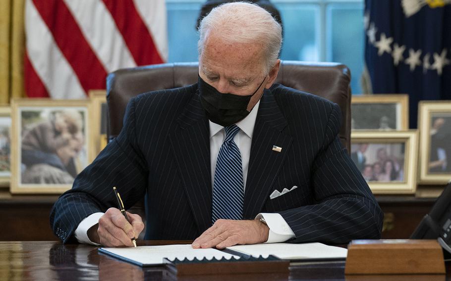 President Joe Biden signs an Executive Order reversing the Trump era ban on transgender individuals serving in military, in the Oval Office of the White House, Monday, Jan. 25, 2021.