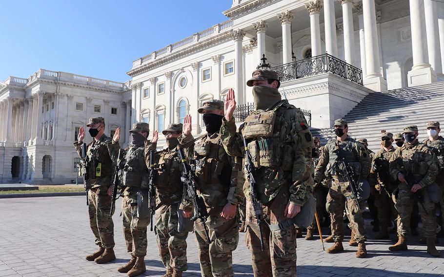 Five members of the Maryland National Guard's 1st Bn., 175th Infantry Regiment, reenlist outside the U.S. Capitol in Washington on Jan. 22, 2021. At least 25,000 Guard members, who were authorized to conduct security, logistical and communications missions leading up to and through the 59th Presidential Inauguration on Jan. 20, earned education benefits for the mission, a National Guard leader said Thursday, Jan. 28.