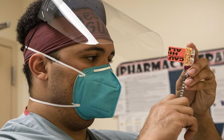 Army 1st Lt. Fernando Echeona draws insulin for coronavirus patients during his shift in a telemetry department at the Adventist Health White Memorial Hospital in Los Angeles on Jan. 22, 2021. He is one of about 185 military medical providers deployed to California to work in civilian hospitals overwhelmed with coronavirus patients.