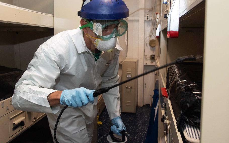 Navy Aviation Electrician’s Mate 3rd Class Kyle Hernandez, assigned to the “Tomcatters” of Strike Fighter Squadron 31, disinfects a berthing aboard the aircraft carrier USS Theodore Roosevelt on April 12, 2020.