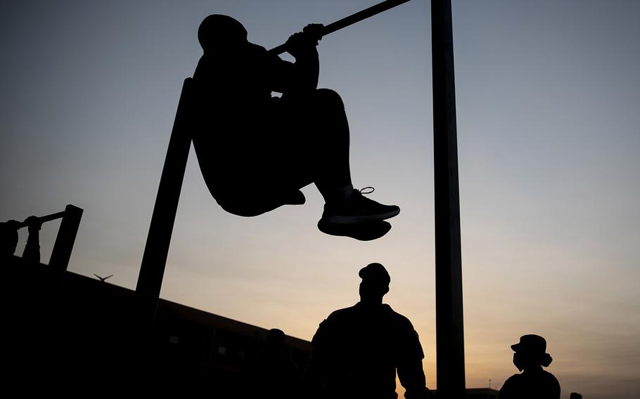 Army 1st Sgt. Christopher Williams, from U.S. Army Central Forward, based in Camp Arifjan, Kuwait, completes a leg tuck during an Army Combat Fitness Test, Jan. 25, 2021.