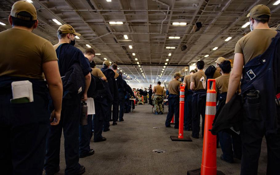 Sailors assigned to the USS Carl Vinson stand in line to receive the coronavirus vaccine, Friday, Feb. 19, 2021, while the aircraft carrier is docked in San Diego.