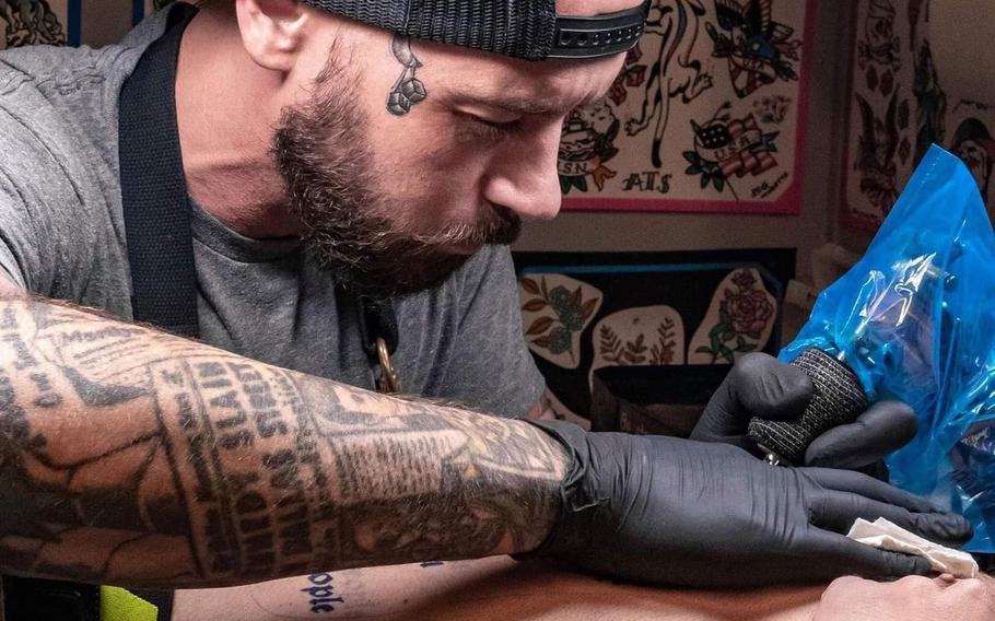 Mathias Moretti creates a tattoo at the first shop on a U.S. military installation at American Tattoo Society on Nellis Air Force Base, Nev., in September 2020. Three more AAFES locations on military bases will be getting tattoo shops.

