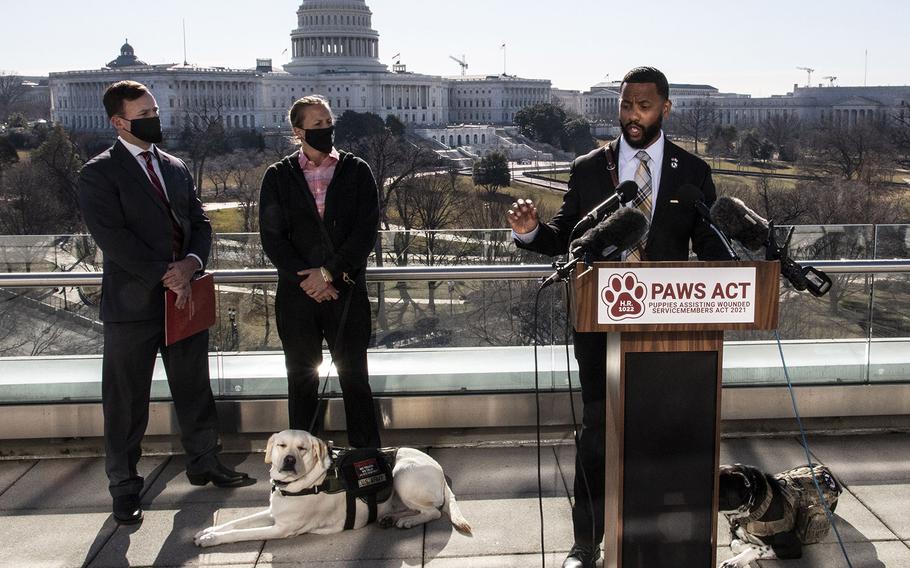 Veteran David Crenshaw, with his service dog Doc at his side, speaks at a Capitol Hill news conference to promote House bill, H.R. 1022, the Puppies Assisting Wounded Servicemembers (PAWS) Act, March 3, 2021. Behind him, left to right, are K9s For Warriors CEO: Rory Diamond and veteran Becca Stephens and her service dog Bobbi.