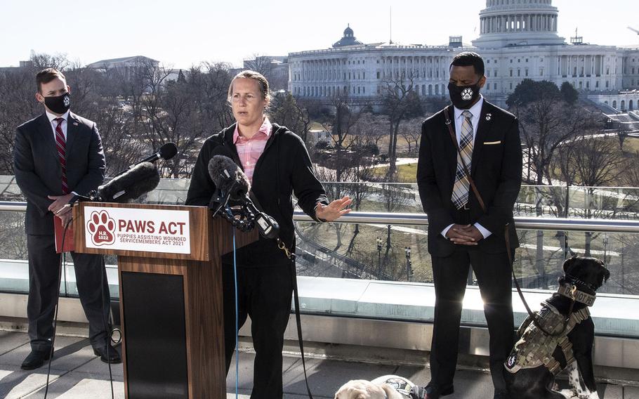 Veteran Becca Stephens, with her service dog Bobbi at her side, speaks at a Capitol Hill news conference to promote House bill, H.R. 1022, the Puppies Assisting Wounded Servicemembers (PAWS) Act, March 3, 2021. Behind her are K9s For Warriors CEO: Rory Diamond and veteran David Crenshaw and his service dog Doc