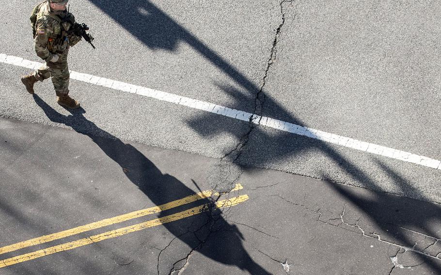 A National Guard soldier casts a long shadow as he walks on Constitution Ave. in Washington, D.C., Wednesday morning, March 3, 2021.