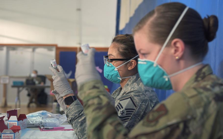 U.S. Air Force Master Sgt. Chona Crose, pharmacy flight chief from the 18th Medical Support Squadron, and U.S. Air Force Staff Sgt. Sydney Wray, a pharmacy technician from the 18th MDSS, draw doses of the Moderna vaccine into syringes at Kadena Air Base, Japan, Feb. 4, 2021.