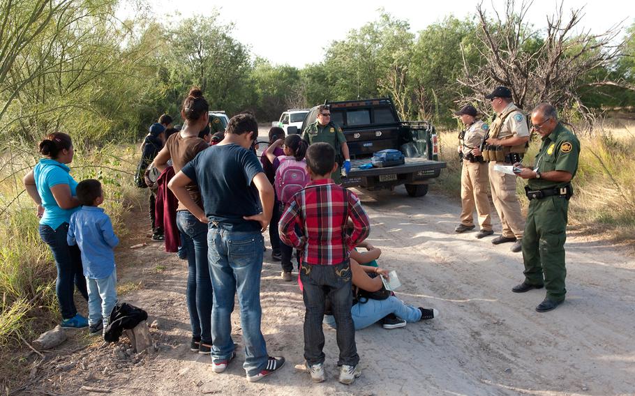 Border Patrol agents process a group of migrants apprehended near the border in this undated photo.