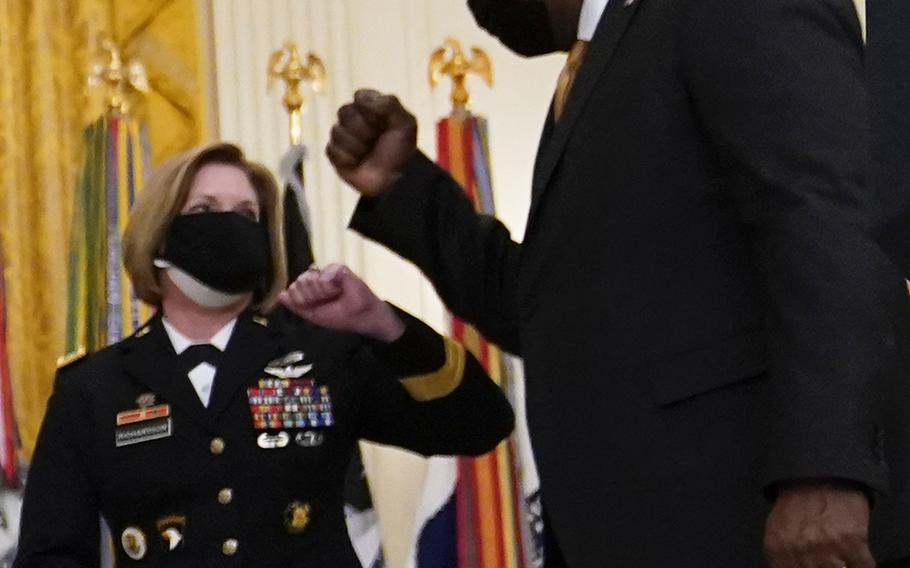Secretary of Defense Lloyd Austin III elbow-bumps U.S. Army Lt. Gen. Laura J. Richardson after a ceremony at the White House on March 8, 2021.