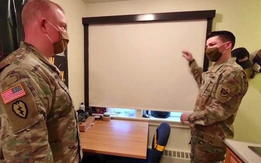 A soldier at Fort Wainwright, Alaska, talks about a blackout shade in his living quarters with Col. Adam Lange, deputy commander for sustainment for U.S. Army Alaska, in this video screenshot. 