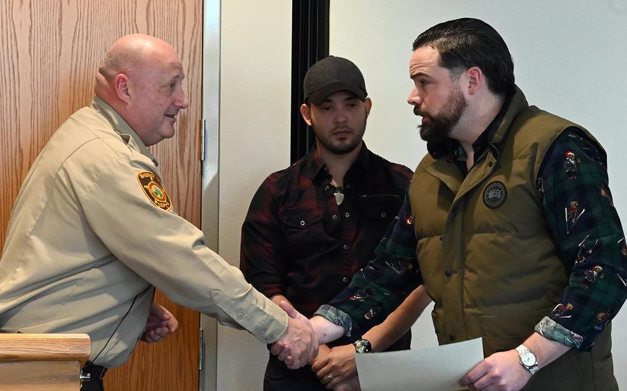 Ward County Sheriff Bob Roed, left, shakes hands with Tech. Sgt. Ryan Fontaine of the 219th Security Forces Squadron in Minot, N.D., Jan. 3, 2020. Fontaine was recognized for helping save a 91-year-old woman who was trapped in a flooding ambulance. Woody Perez-Valdez, center, is also being recognized for his part in the rescue.

