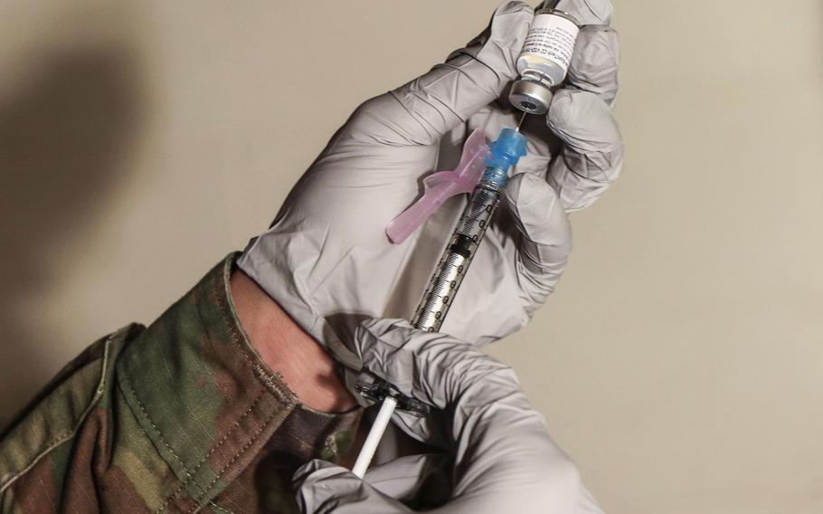 In a January 2, 2021 photo, a William Beaumont Army Medical Center soldier prepares a syringe with the Pfizer vaccine at Stayton Theater.