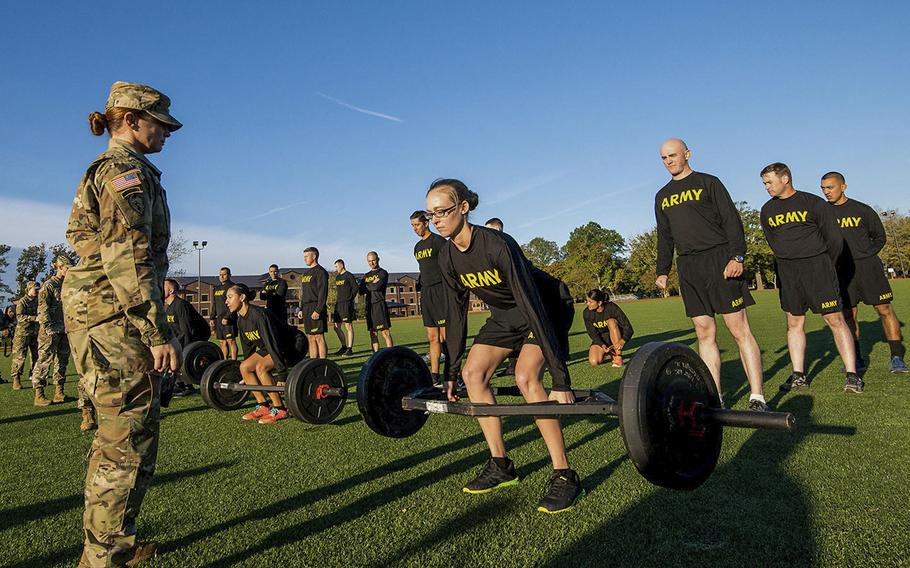 In an Oct. 23, 2018 photo, Army Staff Sgt. Jessica Smiley, a test grader with the Army's Center for Initial Military Training, looks on as soldiers with the 128th Aviation Brigade at Fort Eustis in Virginia demonstrate the deadlift, the first of six events of the new Army Combat Fitness Test.