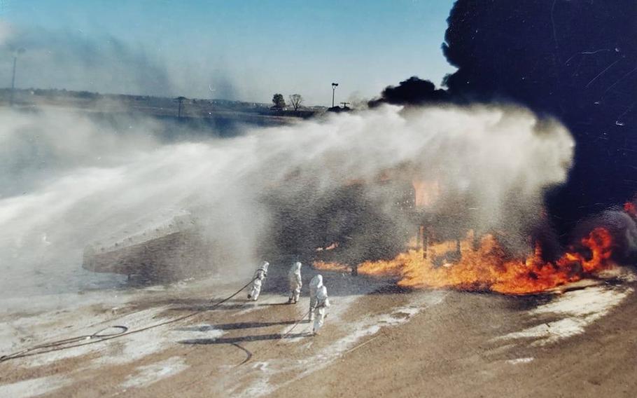 Air Force firefighters being covered in AFFF during training.