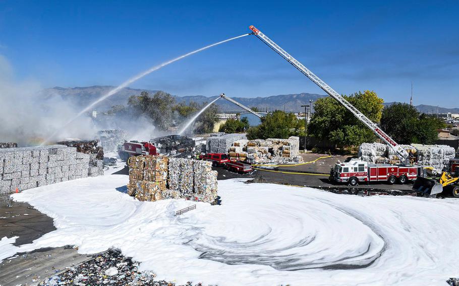 Kirtland Air Force Base firefighters spray foam to tamp down a recycling plant fire in Albuquerque, NM, on Sept. 29, 2020.