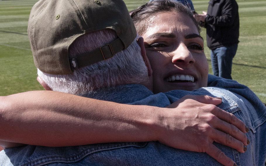 Army Capt. Katie Hernandez is congratulated by family members after setting a world women's record for a mile run in a bomb disposal suit, Saturday, April 3, 2021, at George Mason University in Fairfax, Va.