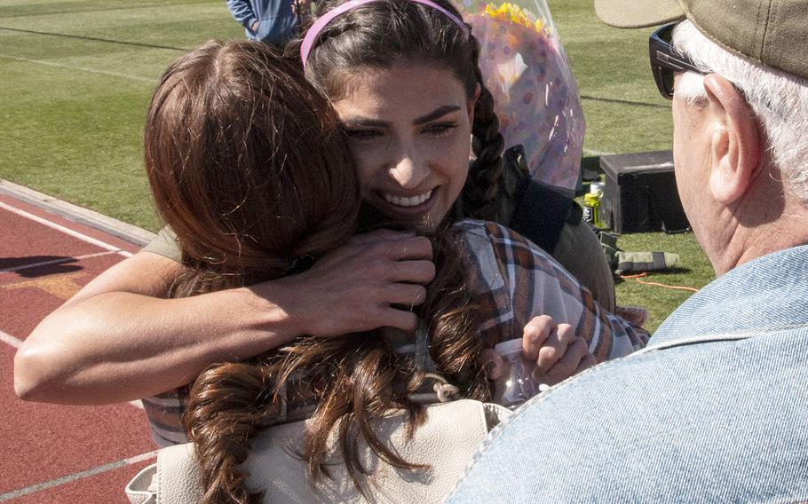 Army Capt. Katie Hernandez is congratulated by family members after setting a world women's record for a mile run in a bomb disposal suit, Saturday, April 3, 2021, at George Mason University in Fairfax, Va.