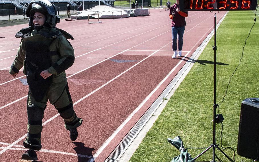 Army Capt. Katie Hernandez reaches the finish line with a world women's record for a mile run in a bomb disposal suit, Saturday, April 3, 2021, at George Mason University in Fairfax, Va.