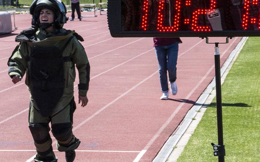 Army Capt. Katie Hernandez approaches the finish line with a world women's record for a mile run in a bomb disposal suit, Saturday, April 3, 2021, at George Mason University in Fairfax, Va.