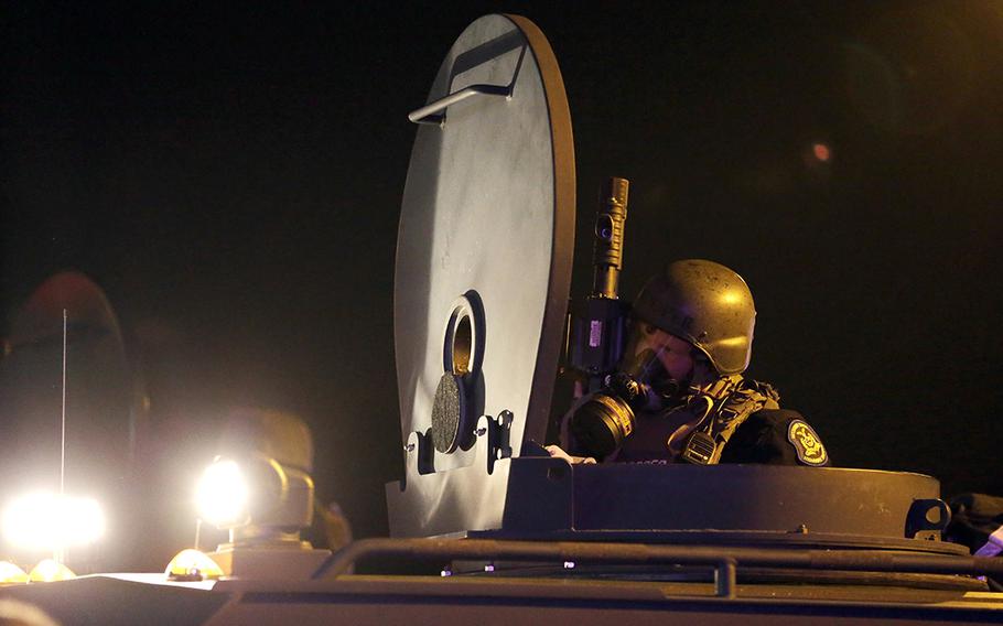 A member of the Missouri Highway Patrol is seen atop an armored personnel carrier in Ferguson, Mo., on Aug. 18, 2014. The Defense Department has transferred $7.4 billion in surplus military equipment to police in nearly all 50 states. House lawmakers on Tuesday, April 6, 2021, were urging President Joe Biden to prevent military weapons and other equipment such as grenades, grenade launchers and armored military vehicles from being provided to local police forces.