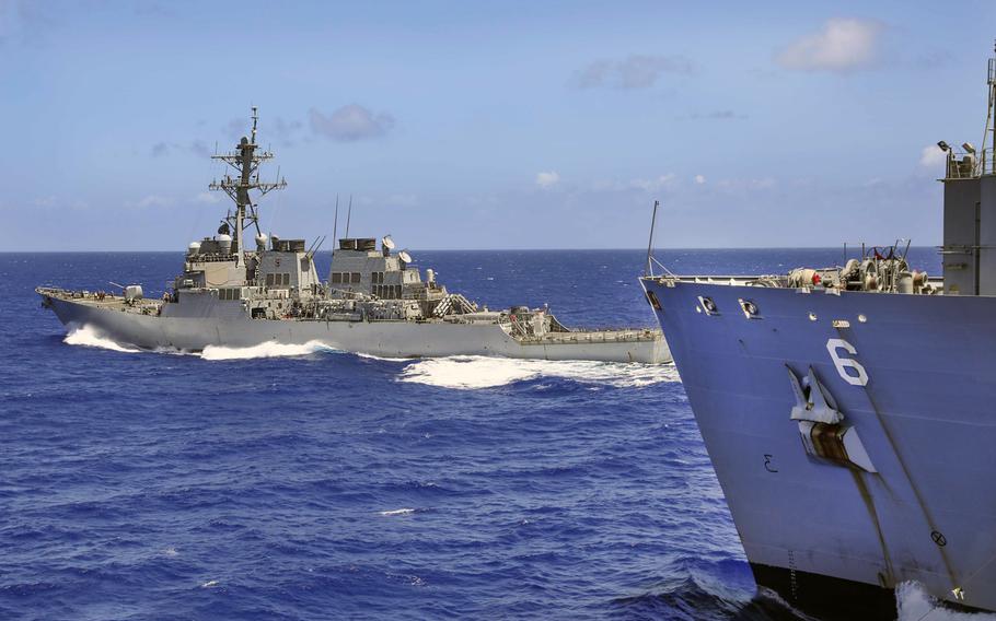 The destroyer USS John S. McCain breaks away from the dry cargo and ammunition ship USNS Amelia Earhart after a replenishment-at-sea in the Philippine Sea, March 26, 2021. Navy combat readiness has fallen in recent years due partly to limited maintenance capacity, a Government Accountability Office report found.