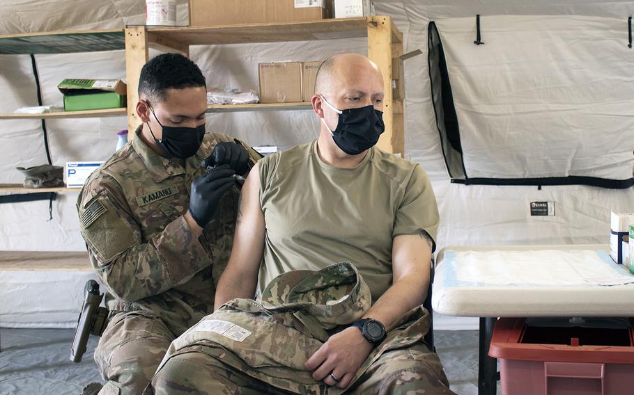 Sgt. Maj. John Shannon receives the COVID-19 vaccine from Sgt. Ryan Kamanu, a medic with the 466th Medical Company Area Support, at the the Role II medical facility at Al Asad Air Base, Iraq, on March 15, 2021. 