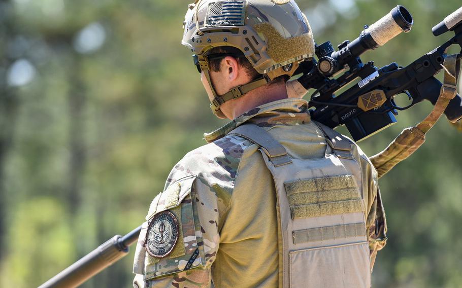 Coast Guard Petty Officer 2nd Class Randy Robinson, with the Maritime Security Response Team in Chesapeake, Virginia, totes a sniper rifle during the Army's Best Sniper Competition at Fort Benning, Ga., on Monday, April 12, 2021.