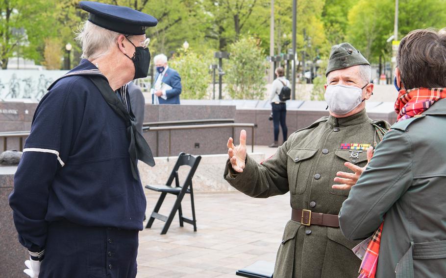 Marine veteran Mark Ragan dressed in a Marine Corps Uniform from the World War I era speaks with friends on Friday, April 16, 2021, prior to the start of a dedication ceremony for the new WWI Memorial in Washington, D.C. Looking on at left dressed in a WWI Navy outfit is Peter Tuttle, a member of the USS Olympia Living History Crew in Philadelphia.