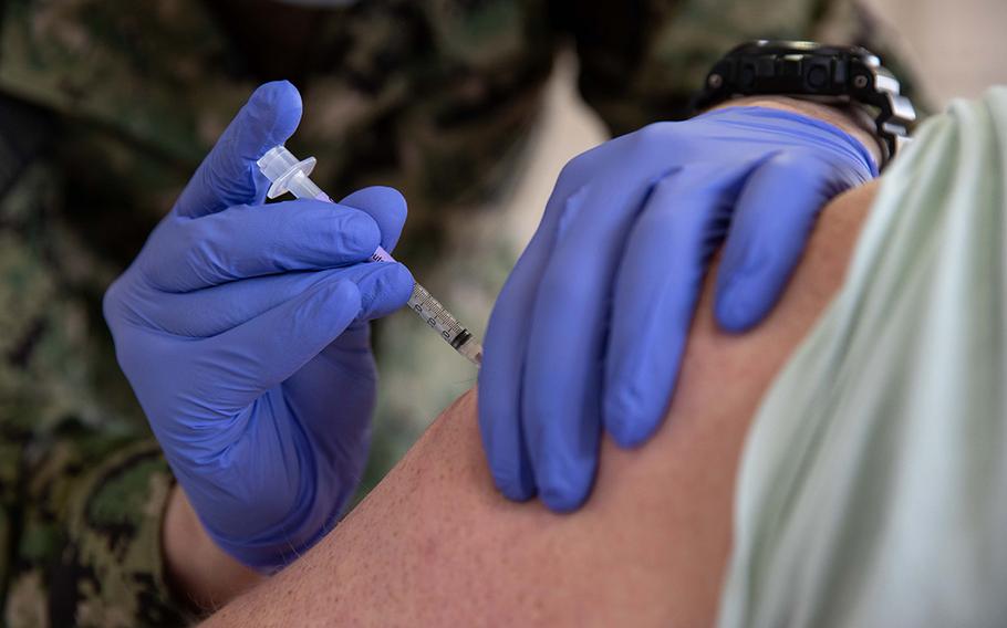 A Navy corpsman administers a COVID-19 vaccine at Naval Station Norfolk, Va., on April 8, 2021.