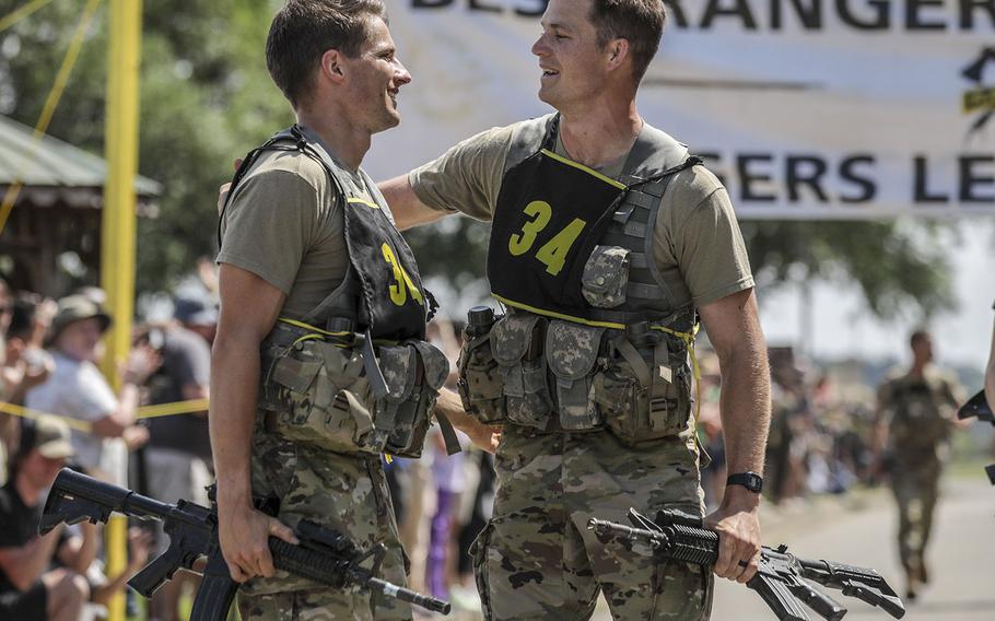 Army 1st. Lt. Vince Paikowski and 1st Lt. Alastair Keys, assigned to the 75th Ranger Regiment, cross the finish line of the final buddy run at Freedom Hall, Fort Benning, Ga., on April 17, 2021.