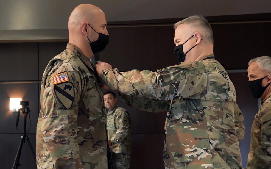 Brig. Gen. Gregory Day, land component commander, pins the Soldier's Medal on Sgt. 1st Class Jedidia Powell at Camp Withycombe, Ore., April 10, 2021. Powell repeatedly ran into a burning house and helped two women and a dog to safety in November 2017.