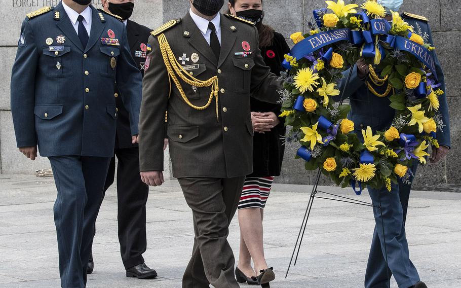 A Ukrainian delegation including Defense Attache Maj. Gen. Borys Krementskyi, left, and Ambassador Extraordinary and Plenipotentiary to the U.S. Markarova Oksana, center background, prepares to lay a wreath during a ceremony at the National World War II Memorial in Washington, D.C. on May 8, 2021, the anniversary of the end of the war in Europe.