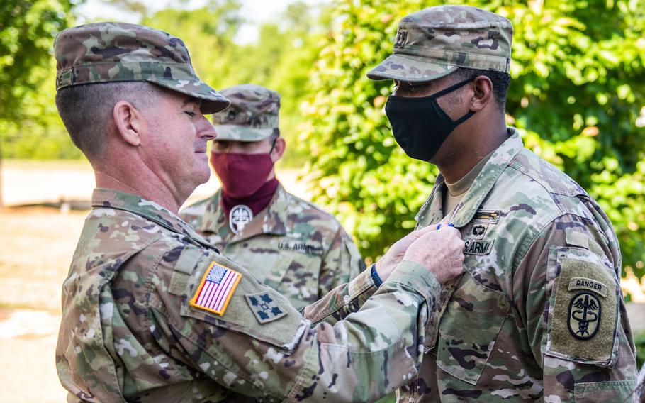 Maj. Gen. Patrick J. Donahoe, Maneuver Center of Excellence commanding general, presents the Soldier's Medal to Capt. Christopher D. Long at Fort Benning, Ga., May 7, 2021. Long tried to save the life of a soldier who was stabbed by her husband by pulling him off the victim and calling for emergency aid.