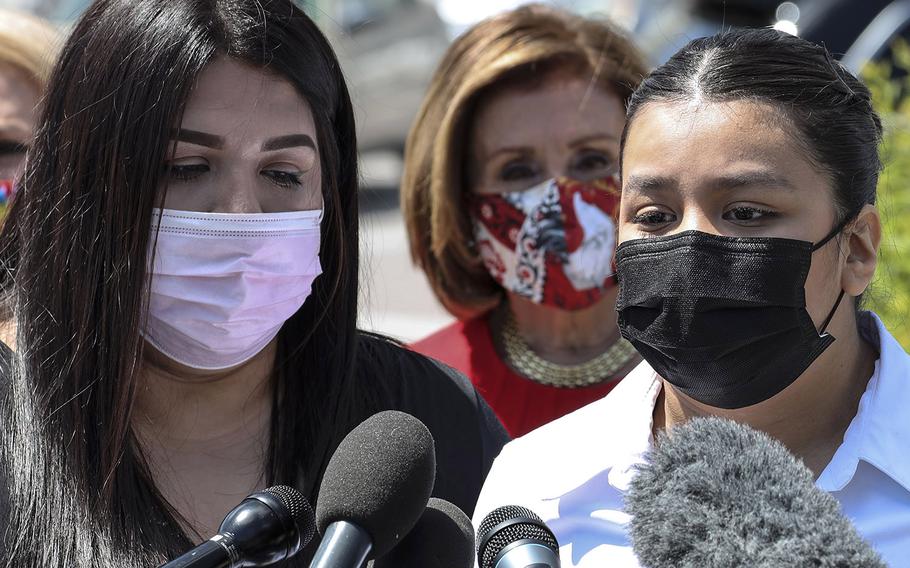 Mayra, left,  and Lupe Guillen, sisters of slain U.S. Army Pfc. Vanessa Guillen, speak at a Capitol Hill news conference to reintroduce the "I am Vanessa Guillen Act" on May 13, 2021. Behind them is House Speaker Nancy Pelosi.