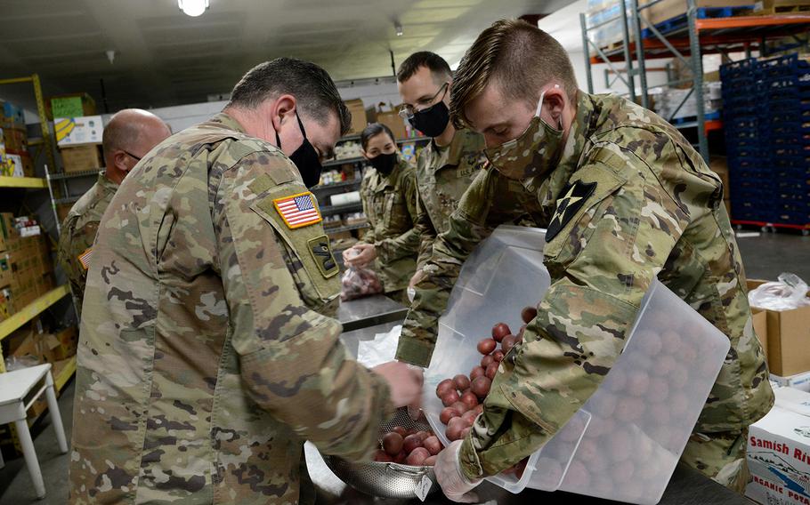 Washington National Guard members assemble food packages at the Helping Hands Food Bank in Sedro-Woolley, Wash., on Monday, May 18, 2020. 