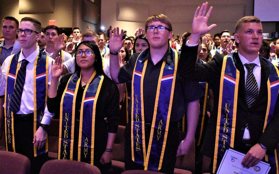 Army recruits raise their right hands while reciting the oath of enlistment during a 2019 induction ceremony at Calvary Community Church in Glendale, Ariz., on Friday, April 26, 2019. 


