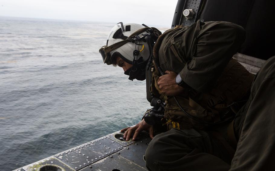 Petty Officer 2nd Class Joseph Rivera, a search and rescue swimmer assigned to the amphibious assault ship USS Makin Island, looks out of a U.S. Navy MH-60 Seahawk while conducting search and rescue relief operations following an AAV-P7/A1 assault amphibious vehicle accident off the coast of Southern California, July 30, 2020.