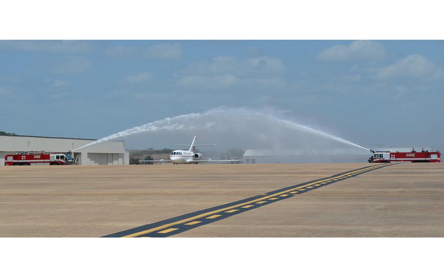 Fires trucks spray water to create an archway Friday as the plane carrying the remains of Army Sgt. James G. Johnston, who died in combat June 25 in Afghanistan, arrives at Fort Hood, Texas.