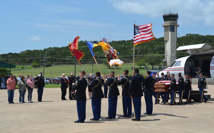 The body of Sgt. James G. Johnston, who died in combat June 25 in Afghanistan, is carried from a plane to a hearse during a ceremony Friday at Robert Gray Army Airfield at Fort Hood, Texas. His family wore Hawaiian shirts in the soldier's honor.