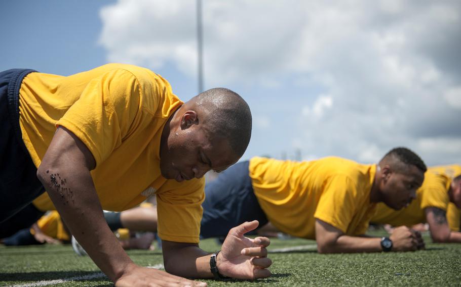 Sailors aboard the aircraft carrier USS Abraham Lincoln perform planks during command physical training July 2015.  The Navy announced it will do away with situps for Navy physical readiness tests, replacing them with a plank exercise.

