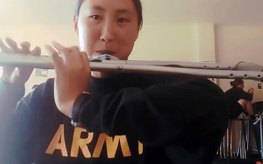 In a screenshot from Reddit, Spc. Jessica Tang plays ‘‘The Army Song’‘ on a crutch she modified to play like a flute after sustaining an injury in training.
