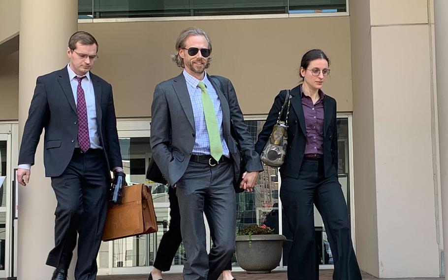 Dr. Anna Gabrielian, right, holds hands with her spouse, Dr. Jamie Lee Henry, as they walk away from federal court in Baltimore after a mistrial was declared in their case on Thursday, June 1, 2023. The Maryland doctors were accused of passing private patient records to an undercover agent posing as a Russian official. 